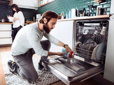 Мужчина чинит посудомоечную машину